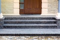 Entrance threshold with marble steps to a wooden door. Royalty Free Stock Photo