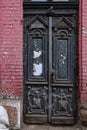 Antique wooden black door and architectural details of dilapidated building needed reconstruction Royalty Free Stock Photo