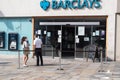 Entrance to Barclays bank on high street with people outside wearing face masks