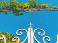 Entrance to the botanic garden in Tbilisi. Beautiful iron gate against the blue sky. Summer day in the city Royalty Free Stock Photo