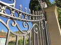 Entrance to the botanic garden in Tbilisi. Beautiful iron gate against the blue sky. Summer day in the city Royalty Free Stock Photo