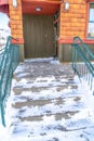 Entrance to building with snowy steps in winter that leads up to the glass door