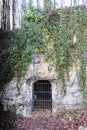 Entrance to a cave in a limestone hill with a closed wrought iron gate Royalty Free Stock Photo