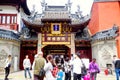 The entrance to the City God Temple, decorated with golden carvings and red-lacquered wood, is located in a busy section of a