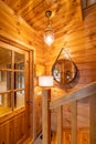 Entrance to a completely wooden house. Door, railings and bright lamps in a small country house.