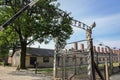 Entrance to concentration camp Auschwitz, Oswiecim. Barbed wire fence with barrack on background. Holocaust memorial.