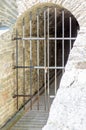The entrance to a dungeon, closed by a rusty metal grating Royalty Free Stock Photo