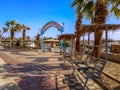 Entrance to El Kheima beach in Sharm El Sheikh. Wooden benches with thatched roofs near