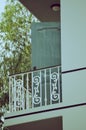 building, Balcony of a red yellow building with blue shutters and various vases