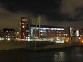 the entrance to knights bridge crossing the river aire in leeds at night with city apartment and office buildings brightly