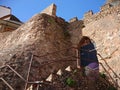 An entrance to a private local vintage historical cottage houses with stairs and high stone walls by the seaside beach