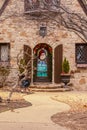 Entrance to rock house with pretty Christmas decorated front door and curving sidewalk