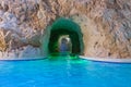 Entrance to stone cave with blue water. Beautiful spa resort. Rocky sea cave.