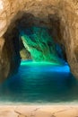 Entrance to stone cave with blue water. Beautiful spa resort. Rocky sea cave.