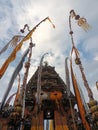 the entrance to the temple with yellow and white banners, tedung and penjor