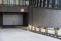 Entrance to underground car park with roller-shutter door and road dividers