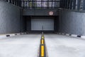 Entrance to underground parking space with roller-shutter door and road dividers