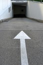 Entrance to an underground parking with a white arrow showing direction.