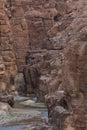 Entrance to the Wadi Mujib canyon in Jordan. Steep rocks and a rapid flowing river carved. Difficult crossing and attraction for Royalty Free Stock Photo