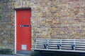 Entrance to the women`s toilet. Red door in a brick wall Royalty Free Stock Photo