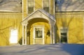 Entrance to yellow home at sunrise in winter, Lyndonville, VT