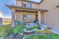 Entrance of a two-storey house building with colorful front yard garden Royalty Free Stock Photo