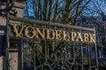 Entrance of the Vondelpark with the cast iron green fence with golden letters against blue sky Royalty Free Stock Photo