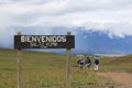 Entrance wood sign to Canaima National Park and hikers