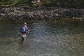 A man practices fishing in a river