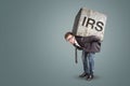 Entrepreneur carrying a large stone with engraved IRS letters