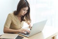 Entrepreneur concept a young female freelancer working on her laptop device typing an urgent document seriously