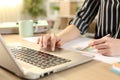 Entrepreneur hands comparing graph report on laptop