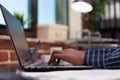 Entrepreneur hands composing email on laptop keyboard sitting at desk