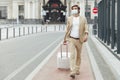 Entrepreneur in mask walking from station with luggage Royalty Free Stock Photo