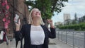 Entrepreneur on a mobile phone works while talking on a smartphone. Attractive blonde smiles happily due to good news Royalty Free Stock Photo