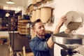 Entrepreneur pouring raw coffee beans into a modern roasting mac