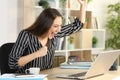 Entrepreneur reads good news on laptop at homeoffice