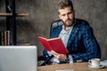 Entrepreneur writing notes sitting at his desk. Young man making business plans with papers and computers on his desk Royalty Free Stock Photo