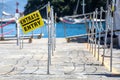 Entry into a corridor in a pier of an Italian port by the sea. No tourists due to the pandemic-induced crisis. Sign with the