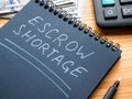 The entry Escrow shortage was made in a notebook with a white marker. Royalty Free Stock Photo