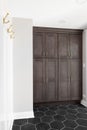 Entryway mudroom with wood cabinets and hexagon tiled floor. Royalty Free Stock Photo