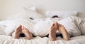 Entwined in a haven of love. a couples feet poking out from under the bed sheets. Royalty Free Stock Photo