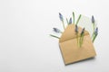 Envelope with beautiful spring muscari flowers and card on light background, flat lay Royalty Free Stock Photo