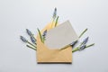 Envelope with beautiful spring muscari flowers and card on light background, flat lay Royalty Free Stock Photo