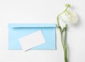 Envelope with card and beautiful ranunculus flower on white background, top view Royalty Free Stock Photo