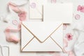 Envelope and card near pink decorations, seals and silk ribbons on white table top view, wedding mockup Royalty Free Stock Photo