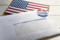 Envelope containing voting ballot papers being sent by mail for absentee vote in presidential election and USA flag Royalty Free Stock Photo