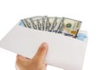 An envelope with dollars in hand is isolated on a white background. a lot of dollars in an envelope. Close-up. Royalty Free Stock Photo