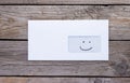 Envelope with emoticon icon in address window on wooden table Royalty Free Stock Photo