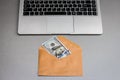 Envelope with one hundred dollar banknote and laptop keyboard Royalty Free Stock Photo